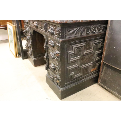 560 - Victorian Carved Dark Oak Desk with brown leather inset top over an arrangement of nine heavily carv... 