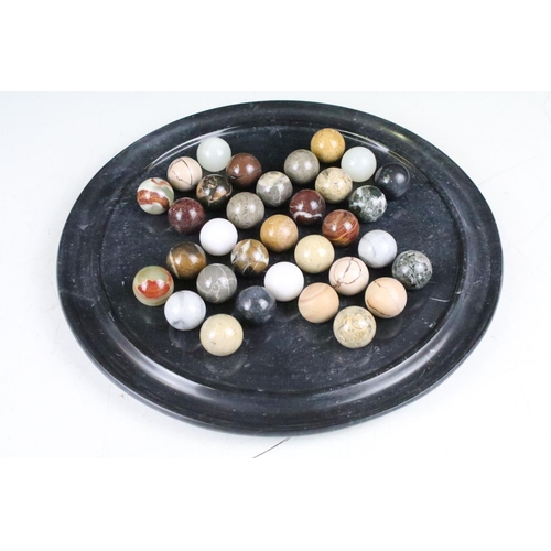 292 - A cased carved stone solitaire set, polished agate balls with granite base in fitted velvet case.