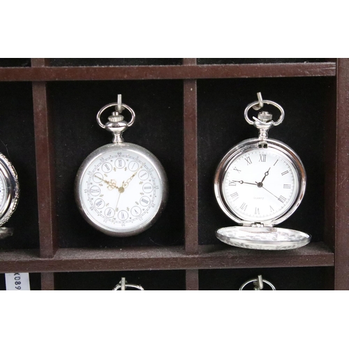 300 - A collection of fifteen contemporary pocket watches contained within a wooden wall mounted display c... 