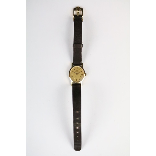 313 - A ladies Omega Geneve wristwatch, gold dial with baton markers on original strap..