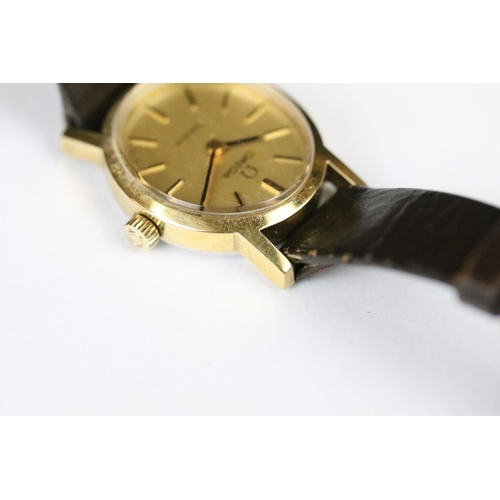 313 - A ladies Omega Geneve wristwatch, gold dial with baton markers on original strap..