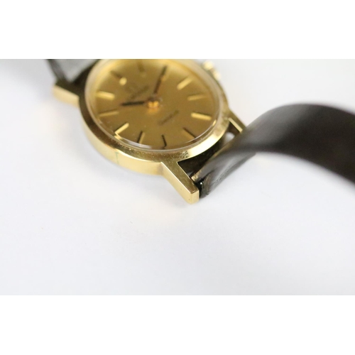 313 - A ladies Omega Geneve wristwatch, gold dial with baton markers on original strap..