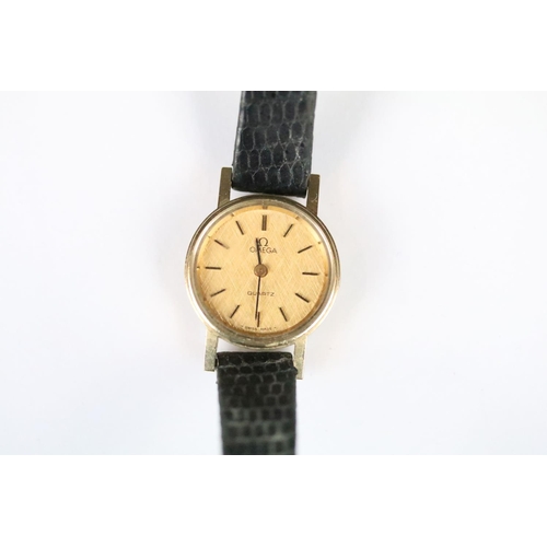 314 - A ladies Omega quartz wristwatch, gold dial with baton markers on original strap..