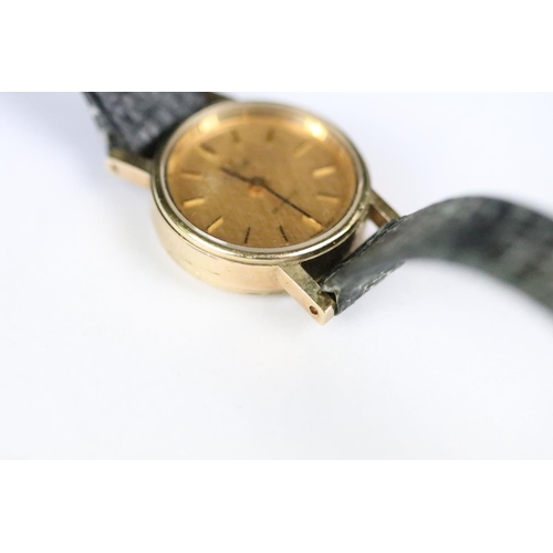 314 - A ladies Omega quartz wristwatch, gold dial with baton markers on original strap..