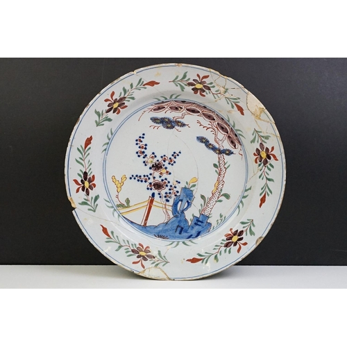 12 - 18th Century English Delft plate featuring a hand painted garden scene. A/F, extensively repaired. M... 