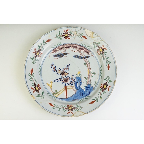 12 - 18th Century English Delft plate featuring a hand painted garden scene. A/F, extensively repaired. M... 