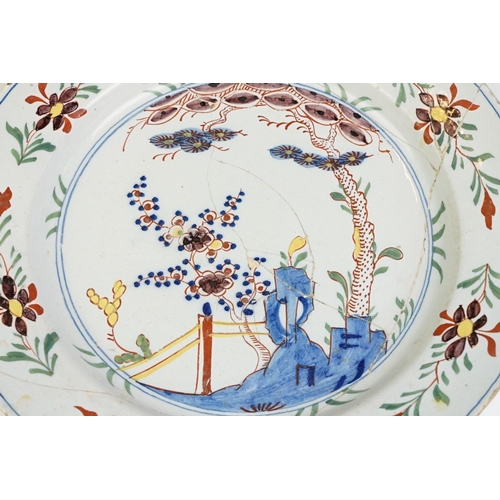 12 - 18th Century English Delft plate featuring a hand painted garden scene. A/F, extensively repaired. M... 