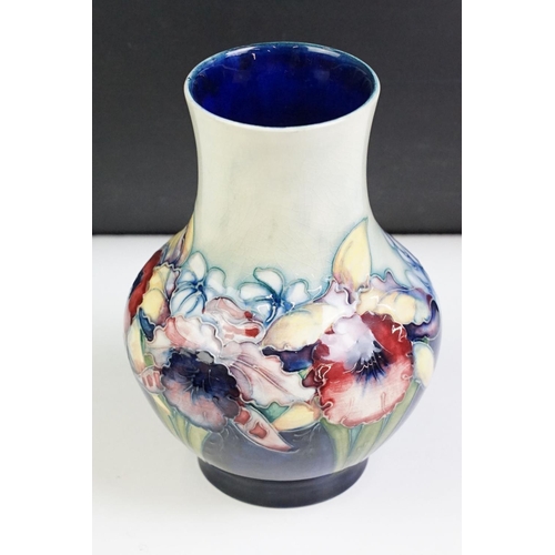 24 - Moorcroft Orchid pattern small baluster vase with tube lined detailing. Impressed Moorcroft mark to ... 