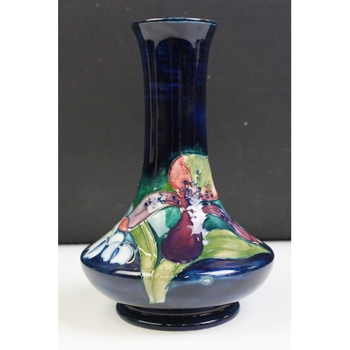 25 - Moorcroft Orchid pattern vase having a blue ground with tube lined floral detailing. Impressed marks... 