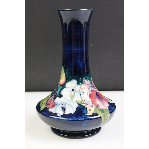 25 - Moorcroft Orchid pattern vase having a blue ground with tube lined floral detailing. Impressed marks... 