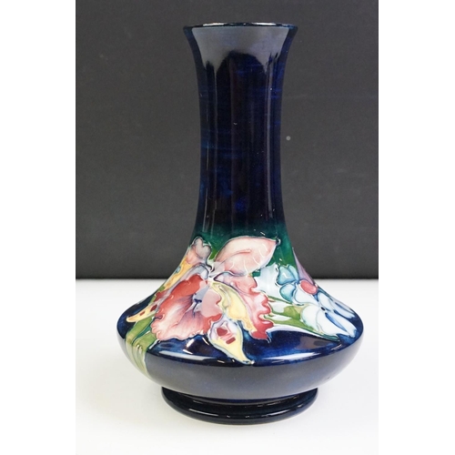 25 - Moorcroft Orchid pattern vase having a blue ground with tube lined floral detailing. Impressed marks... 