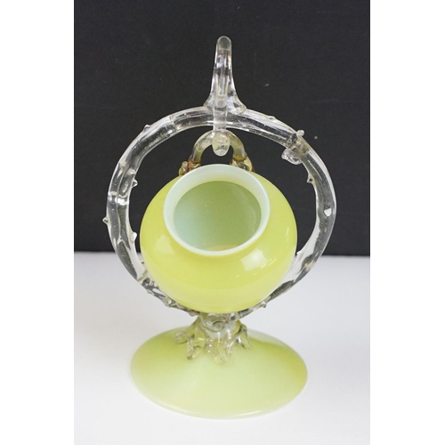 52 - 19th Century Victorian vaseline glass ornament having a small vase suspended to the centre raised on... 