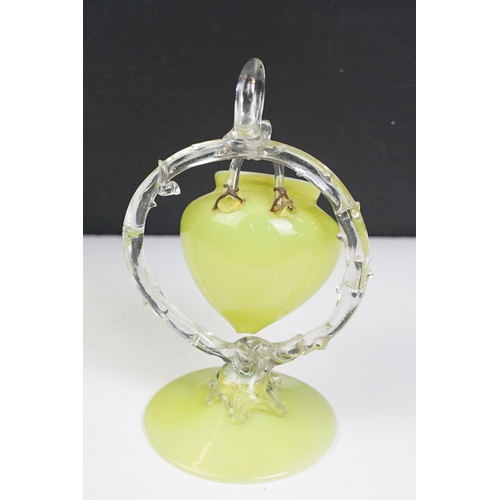 52 - 19th Century Victorian vaseline glass ornament having a small vase suspended to the centre raised on... 