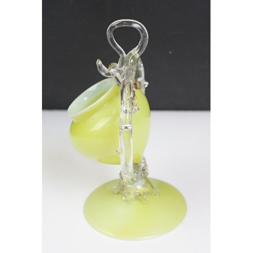 52 - 19th Century Victorian vaseline glass ornament having a small vase suspended to the centre raised on... 