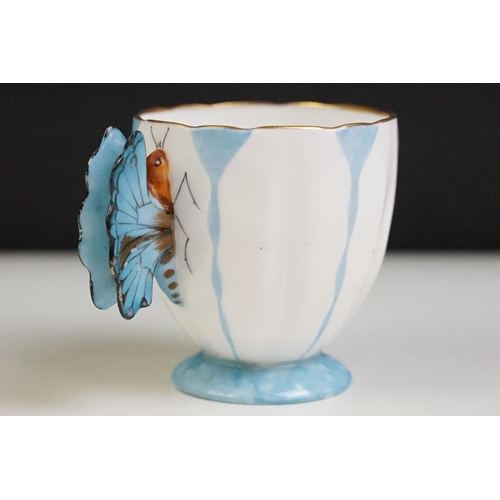 6A - Aynsley Art Deco tea cup and saucer having a butterfly formed handle, gilt rims and blue hand painte... 