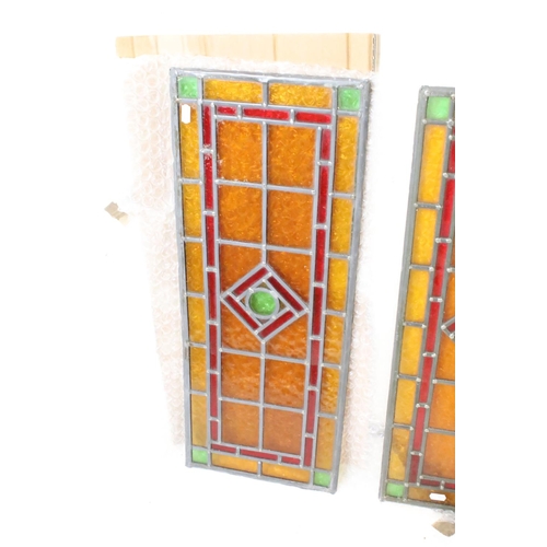 358 - Pair of Art Deco leaded stained glass panels, each with a central green roundel bordered by a red lo... 