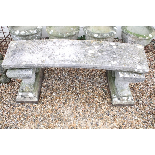 528 - Reconstituted stone garden bench with curved seat raised upon lion supports (matched), approx 175cm ... 