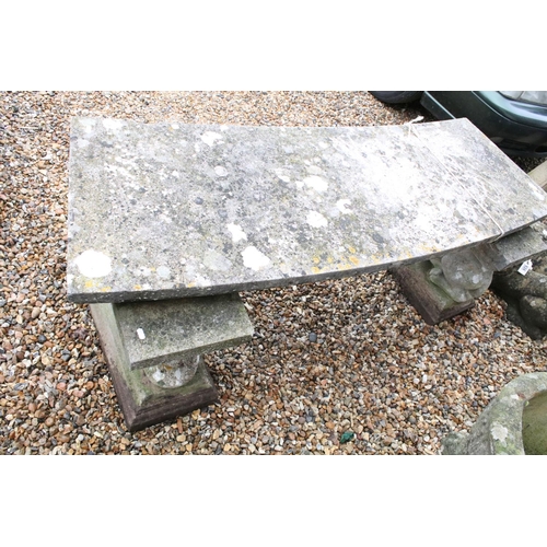 528 - Reconstituted stone garden bench with curved seat raised upon lion supports (matched), approx 175cm ... 