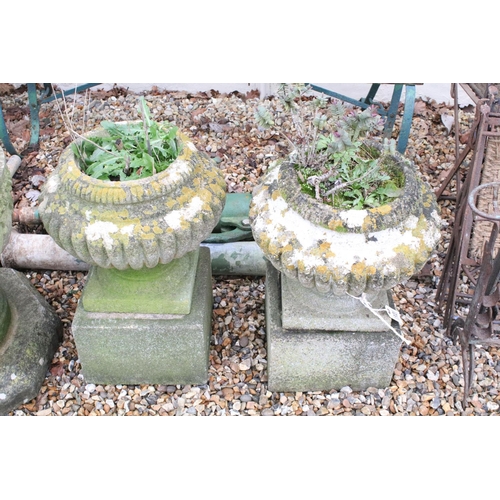 531 - Pair of reconstituted stone garden planters of gadrooned form, raised on square stone plinths (measu... 