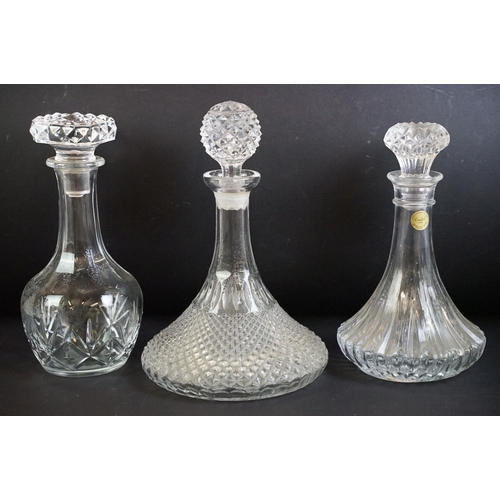 109 - Collection of twelve 20th century glass decanters of varying forms to include a ships decanters, hob... 