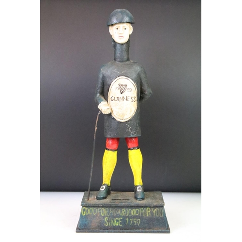 127 - Cast iron reproduction Guinness advertising money box featuring a figure standing on a pedestal base... 