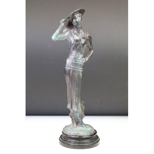 136 - Bronze figure of a lady wearing a wide-brim hat, raised on a circular pedestal base. Measures approx... 