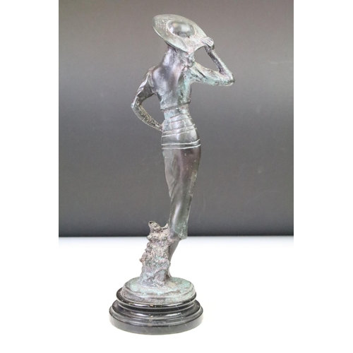 136 - Bronze figure of a lady wearing a wide-brim hat, raised on a circular pedestal base. Measures approx... 