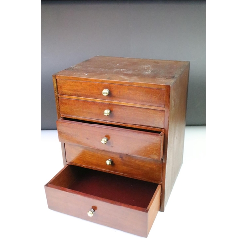 146 - Mahogany desk top set of drawers having a bank of five drawers with brass knob handles. Measures 27.... 