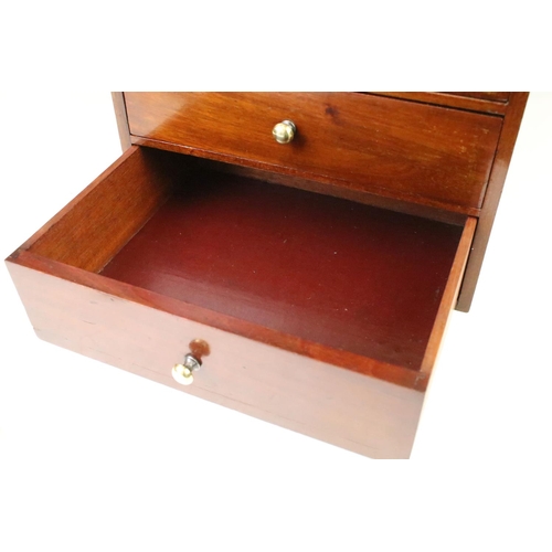 146 - Mahogany desk top set of drawers having a bank of five drawers with brass knob handles. Measures 27.... 