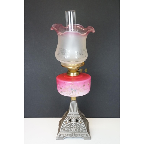 170 - Late Victorian / early 20th Century oil lamp having a cast metal base with pink glass reservoir with... 