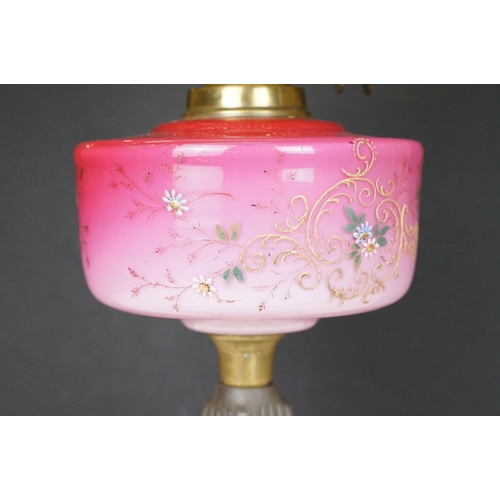 170 - Late Victorian / early 20th Century oil lamp having a cast metal base with pink glass reservoir with... 