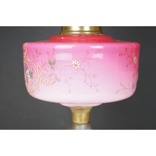 170 - Late Victorian / early 20th Century oil lamp having a cast metal base with pink glass reservoir with... 