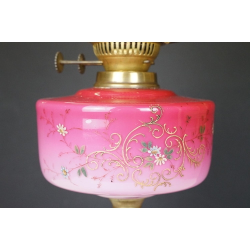 170 - Late Victorian / early 20th Century oil lamp having a cast metal base with pink glass reservoir with... 