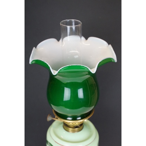 171 - Late Victorian / early 20th Century oil lamp having a cast metal base, green glass reservoir with ha... 