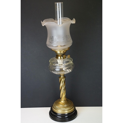 172 - Late Victorian / early 20th Century oil lamp raised on a round black pedestal base, brass twist desi... 