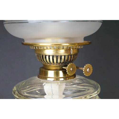 172 - Late Victorian / early 20th Century oil lamp raised on a round black pedestal base, brass twist desi... 