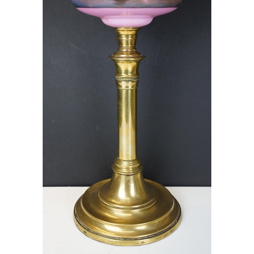 175 - Late Victorian / early 20th Century oil lamp having a round brass stepped base, pink reservoir with ... 