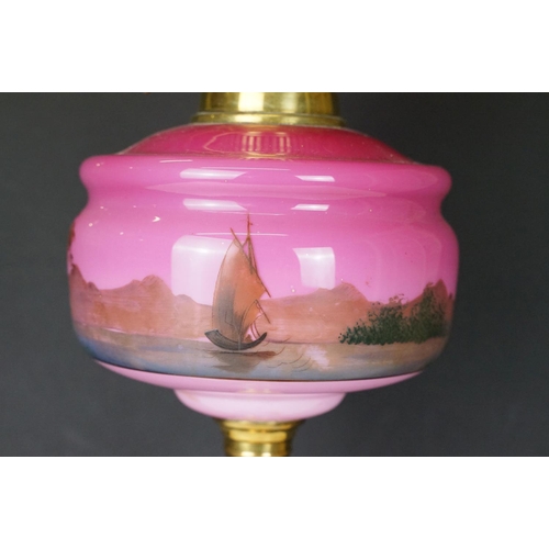 175 - Late Victorian / early 20th Century oil lamp having a round brass stepped base, pink reservoir with ... 