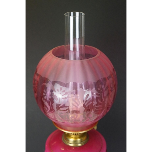 175 - Late Victorian / early 20th Century oil lamp having a round brass stepped base, pink reservoir with ... 