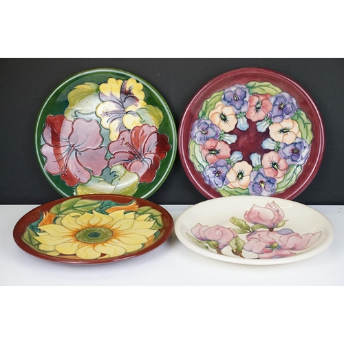 78 - Four Moorcroft pottery plates, to include an early-to-mid 20th C Hibiscus pattern plate on green gro... 