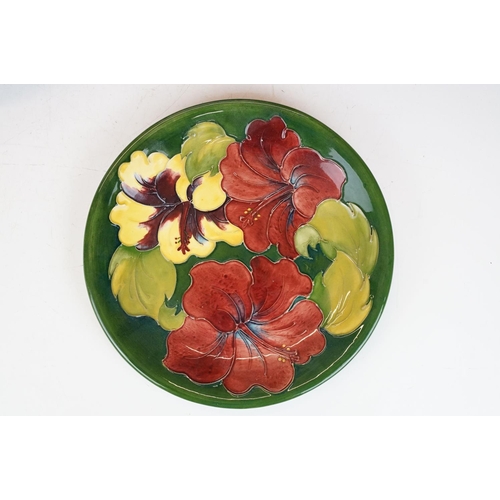 78 - Four Moorcroft pottery plates, to include an early-to-mid 20th C Hibiscus pattern plate on green gro... 