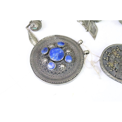 330A - Collection of middle eastern silver white metal pendants to include an Afghan coloured gem set penda... 