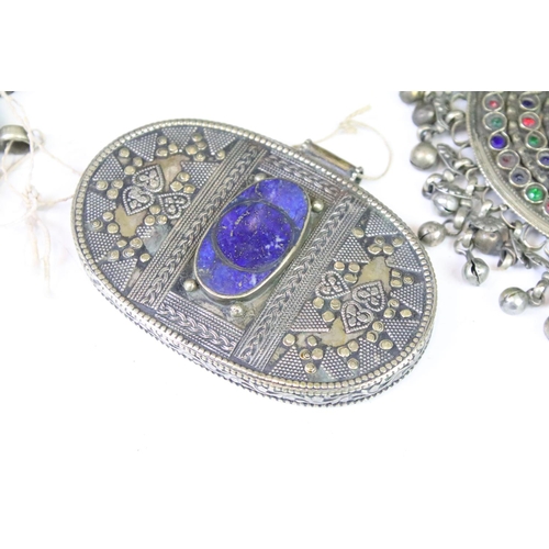 330A - Collection of middle eastern silver white metal pendants to include an Afghan coloured gem set penda... 