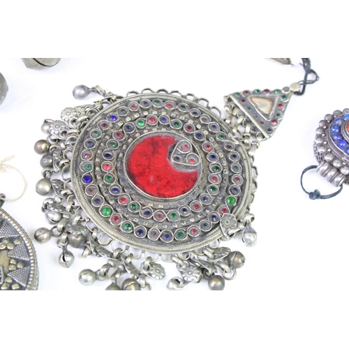 330A - Collection of middle eastern silver white metal pendants to include an Afghan coloured gem set penda... 