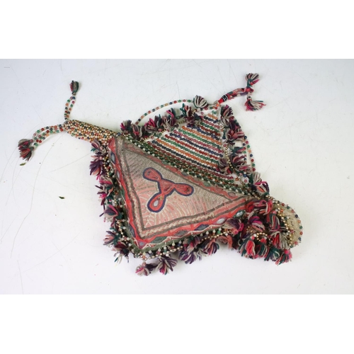 295 - An Afghan face veil adorned with coins together with a selection of hand stitched head wear and embe... 