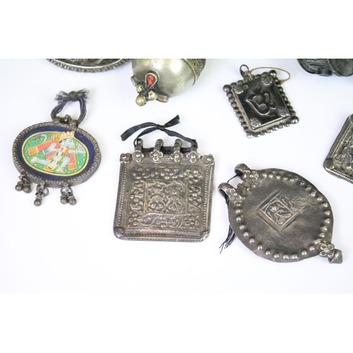 295A - A collection of mainly Indian white metal amulets including an example set with a large turquoise pa... 