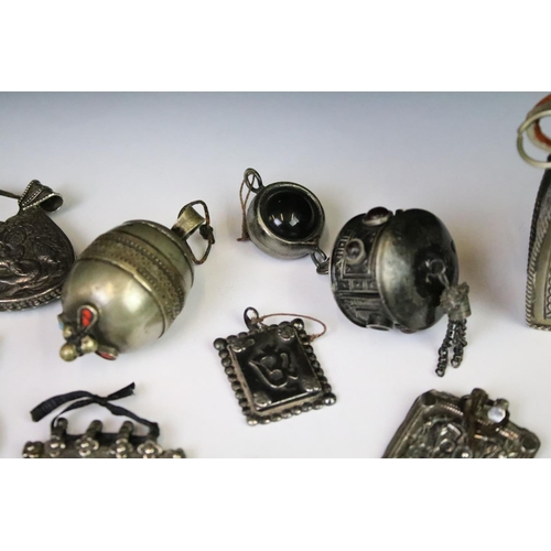 295A - A collection of mainly Indian white metal amulets including an example set with a large turquoise pa... 