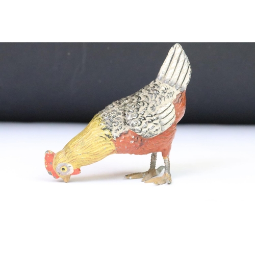 208 - A collection of three ornamental cold painted metal chicken figures.