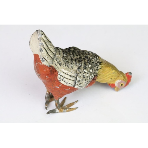 208 - A collection of three ornamental cold painted metal chicken figures.