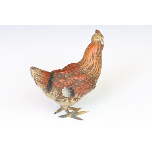 208 - A collection of three ornamental cold painted metal chicken figures.